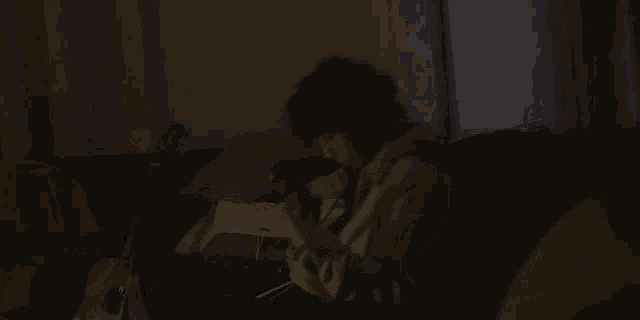 a person wearing headphones sits on a couch in the dark