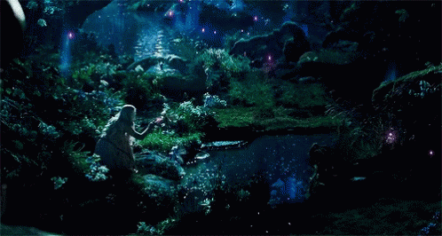 light-haired woman in a dress crouched by a river in a forest at night time, with glowing fairies around her