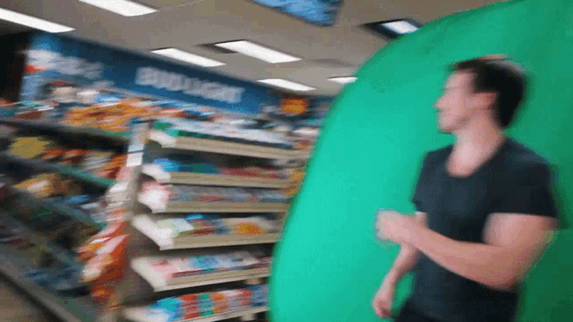 a man running in a store with a green screen behind him