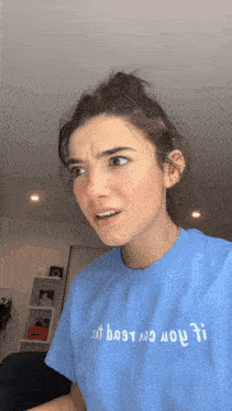 a woman wearing a blue t-shirt that says " i 'm busy " on it