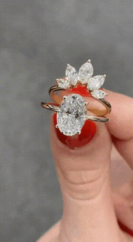 a woman 's hand is holding a ring with a diamond in it .