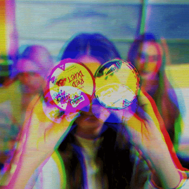 a woman is holding a container of diet m&ms in front of her face
