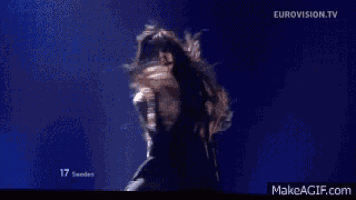 a woman with long hair is dancing on stage .