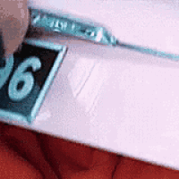 a person is holding a piece of paper that has the number 6 on it