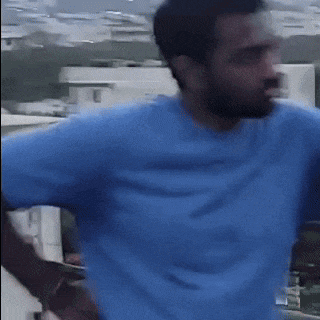 a blurry picture of a man with a beard wearing a blue t-shirt .