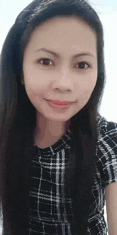 a woman with long black hair is wearing a plaid shirt and smiling at the camera .