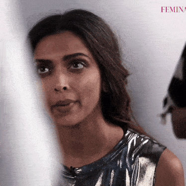 a close up of a woman 's face with the word femina in the background