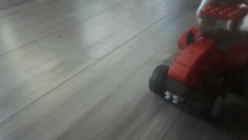 a blurred image of a toy tractor on a wooden floor