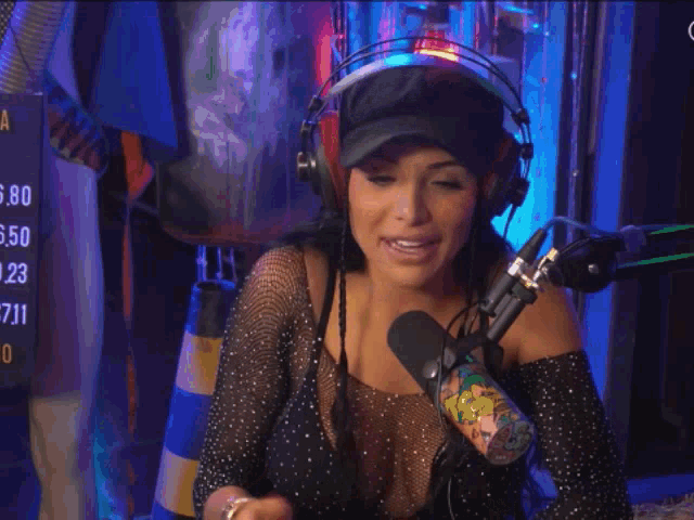 a woman wearing headphones and a hat is giving a thumbs up sign