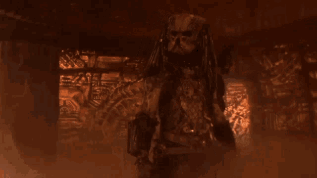 a predator is standing in front of a wall that has a drawing on it