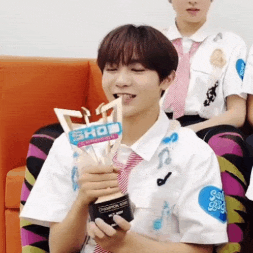 a young man holding a trophy that says show