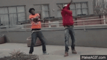 two men are dancing on a rooftop with their arms in the air .