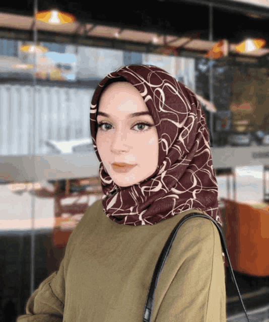 a woman wearing a hijab is standing in front of a building