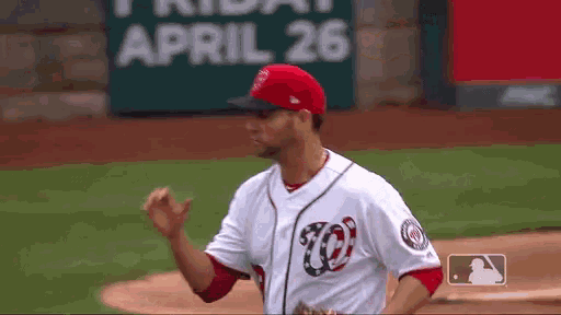 a baseball player wearing a washington nationals jersey stands on the field