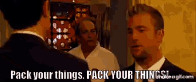 a man in a suit and tie is talking to another man in a white shirt .