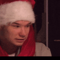 a man is wearing a santa hat and a red scarf around his neck .