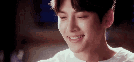 a close up of a young man 's face with his eyes closed and smiling .