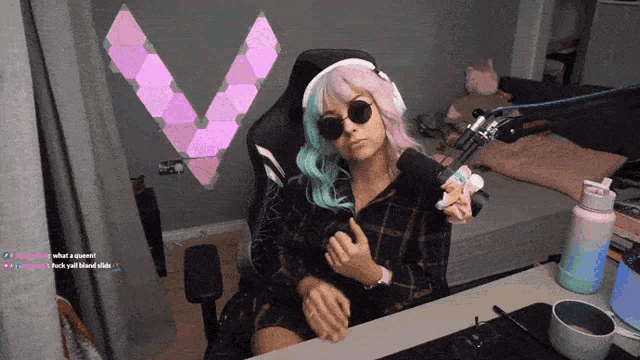 a woman wearing sunglasses and headphones is sitting at a desk with a microphone
