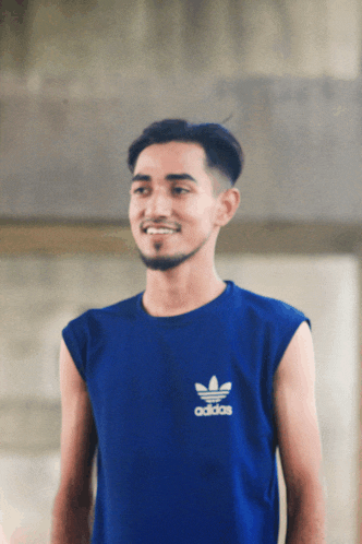 a man wearing a blue adidas tank top