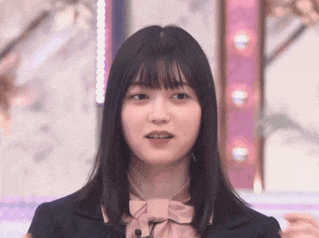 the girl is wearing a pink bow tie and a black suit .