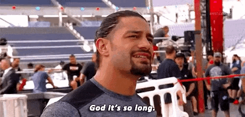 roman reigns is smiling and saying `` god it 's so long '' in front of a crowd of people .