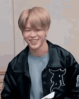 a close up of a person wearing a black jacket and smiling .