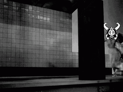 a black and white photo of a cartoon character with horns on a wall .