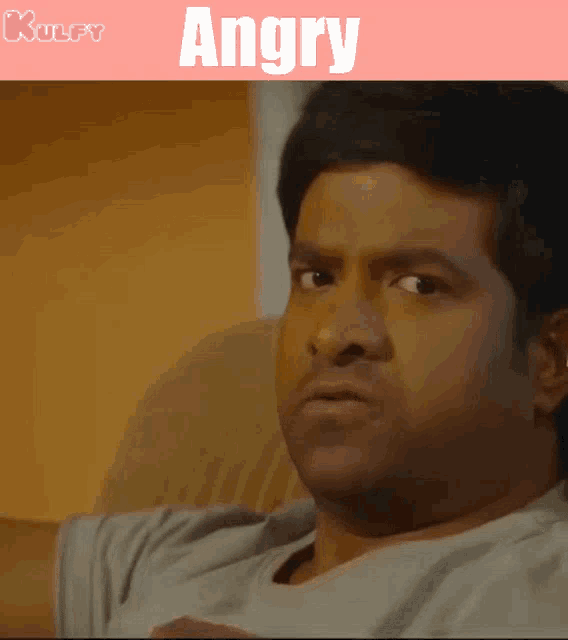 a man is sitting on a couch and the word angry is on the bottom
