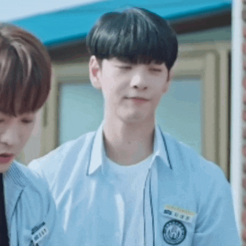 a boy in a school uniform is standing next to another boy in a school uniform .