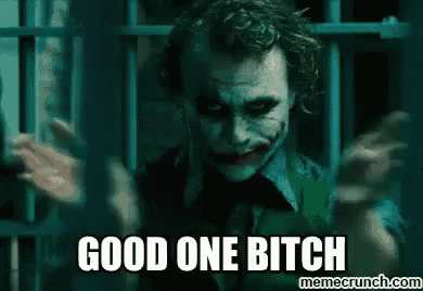 the joker from the movie the dark knight is standing in a jail cell behind bars .