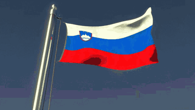 a red white and blue flag waving in the wind against a blue sky
