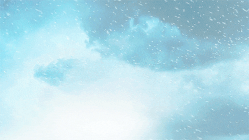 a blue sky with white clouds and snow falling on it