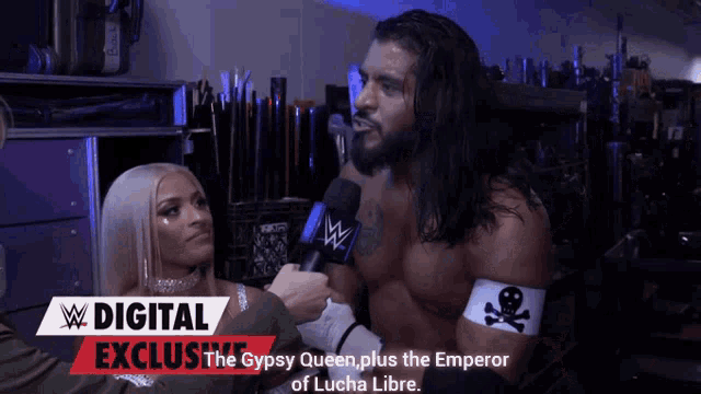 a woman is interviewing a wrestler with a digital exclusive banner