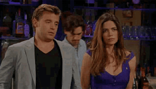 a man and a woman are standing next to each other in a bar