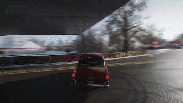a red car with a new york license plate is driving on a road