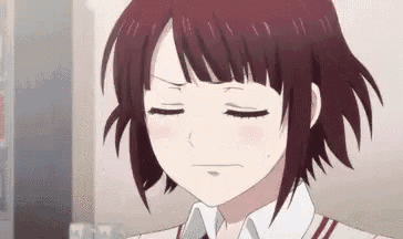 a close up of a girl with short red hair making a funny face .