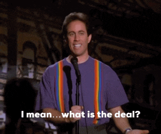 a man in a purple shirt stands in front of a microphone and says " what is the deal "