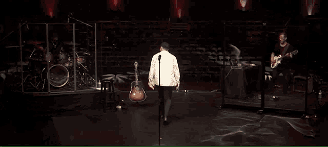 a man singing into a microphone on stage