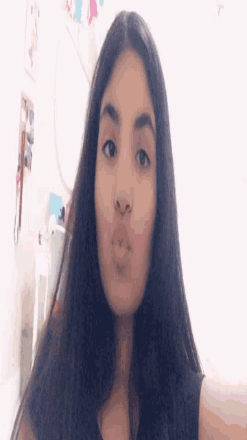 a girl with long hair is taking a selfie with her mouth open