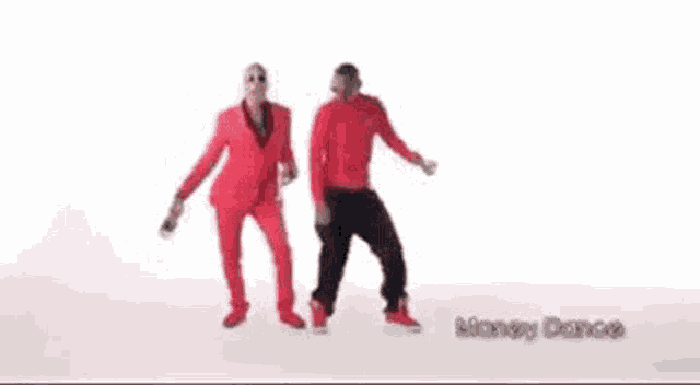two men in red suits and sunglasses are dancing .