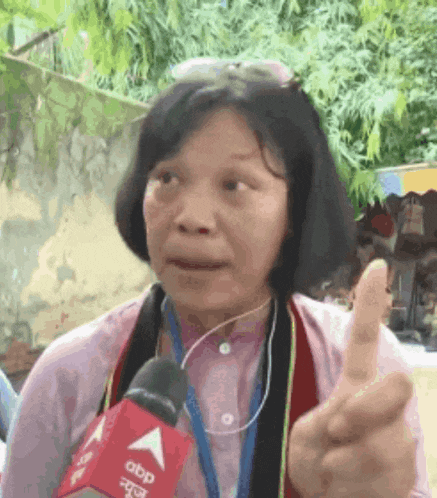 a woman giving a thumbs up while wearing a microphone that says abp