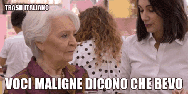 an older woman with gray hair is sitting next to a younger woman in a polka dot shirt .