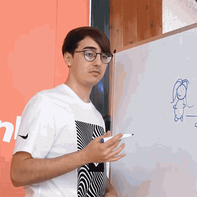 a man standing in front of a white board with a drawing of a girl on it
