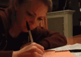 a woman writes on a piece of paper with a marker