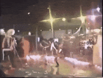 a group of people are dancing on a stage in a club .