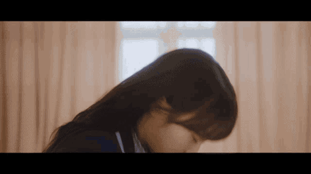 a close up of a woman 's face with her eyes closed in front of a window .
