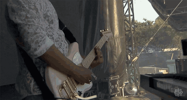 a man playing a guitar with the word illa on the bottom left