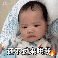 a baby is sitting in a high chair and has chinese writing on his face