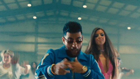 a man in a blue jacket is dancing with a woman