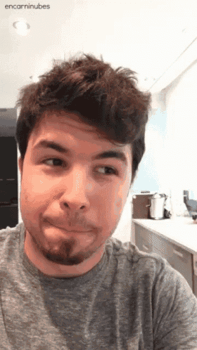 a man with a beard is making a funny face and the words encarninubes are on the bottom right
